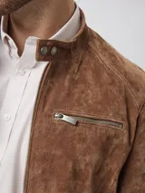 Campera biker de cuero color marrón, con cuello mao, cierre frontal metálico, bolsillo en el pecho con cierre y bolsillos laterales.