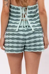 Top tejido a rayas horizontales en tonos verde agua y gris, con cuello halter y espalda descubierta.