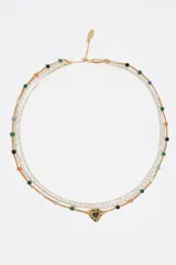 Collar multicapa dorado con cuentas de colores, perlas y un dije en forma de corazón con esmalte negro.