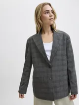 Blazer de sarga con diseño oversize, cuello con solapas y cierre frontal de dos botones. Presenta un estampado de cuadros en tonos gris oscuro y una estructura definida.