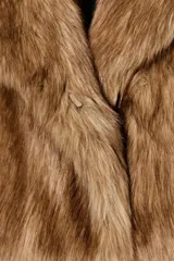 Chaqueta corta de pelo sintético color marrón claro, con cuello solapa y manga larga.