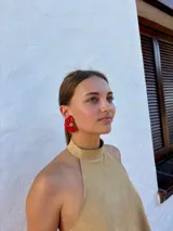 Aros tipo caravanas con diseño de flor irregular en color rojo vibrante y centro con detalle de pequeñas perlas.