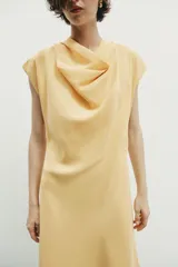 Vestido midi de corte evasé confeccionado en mezcla de modal, con cuello fluido tipo drapeado, manga sisa caída y abertura en la espalda.