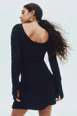 Vestido corto de punto acanalado con escote bote, mangas largas y falda acampanada con vuelo. Presenta un diseño ajustado en el torso y espalda descubierta en U.