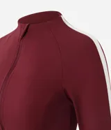 Campera deportiva Get Over en microfibra bordó, de ajuste próximo al cuerpo, con cuello alto, cierre frontal por cremallera y franja blanca contrastante desde los hombros hasta los puños.