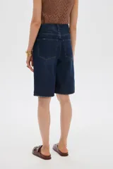 Bermuda de jean azul de tiro alto, corte boyfriend con bolsillos y terminaciones deshilachadas.