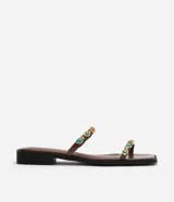 Sandalias planas estilo mule marrones, confeccionadas en PU, con diseño de dedo, dos tiras finas decoradas con aplicaciones de resina y detalles metálicos dorados.