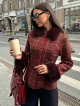Chaqueta entallada de diseño clásico con estampado de cuadros escoceses en tonos bordó. Presenta cuello y puños con detalle de pelo sintético al tono, cierre frontal con botones y corte ajustado.