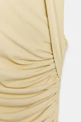 Vestido midi negro con escote asimétrico, sin mangas y detalle de drapeado delantero.