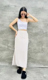 Pollera larga color beige con rayas verticales, de corte recto y abertura lateral.