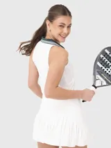 Top deportivo sin mangas con cuello polo, diseño tipo crop y escote en V. Presenta un diseño bicolor con cuerpo blanco y detalles en cuello y solapa en color verde oscuro.