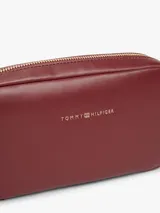 Cartera bandolera Tommy Hilfiger modelo Essential de color bordó, con acabado liso, cierre de cremallera y correa ajustable de jacquard. Presenta el logo y la inscripción de la marca en bajo relieve en la parte delantera.