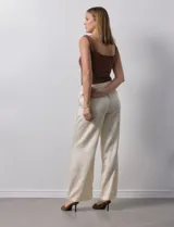 Pantalón palazzo color crudo de lyocell marca Nanette, con pretina elastizada, lazo de ajuste y bolsillos delanteros.