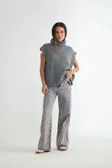 Chaleco de punto gris con cuello alto, diseño sin mangas y corte holgado.