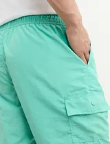 Short de baño verde agua con un bolsillo lateral con solapa y cordón ajustable en la cintura.