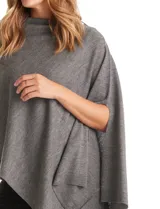 Poncho tejido de punto con diseño asimétrico y aberturas laterales para los brazos.