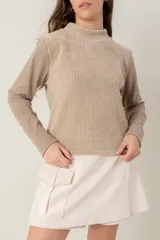 Polera de manga larga con diseño combinado, presentando un panel frontal de tejido acanalado en tono beige y mangas de tela lisa en tono arena. Posee cuello alto y corte recto.
