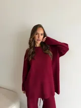 Conjunto de dos piezas color tostado, compuesto por un buzo de cuello redondo con mangas largas y hombros caídos, y un pantalón de corte recto con cintura elástica y cordón ajustable.