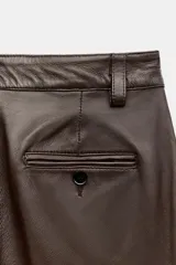 Pantalón de tiro medio confeccionado en 100% piel de color marrón, con diseño flare y costuras decorativas.