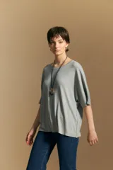 Remera de calce relajado con silueta fluida, confeccionada en tejido de viscosa con elastano. Presenta cuello redondo, mangas cortas y un diseño minimalista de caída suave.