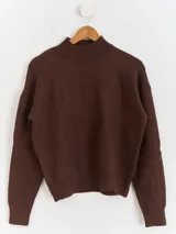 Sweater de punto color blanco con cuello polera, manga larga y diseño bordado al tono con motivos florales en el frente y las mangas.