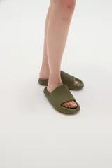 Sandalias de goma color verde oliva, estilo slide, con suela gruesa y plataforma texturizada.