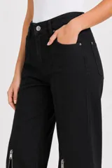 Pantalón de jean negro de tiro alto y corte flare, con bolsillos y aberturas con cierre en los botaguas delanteros.