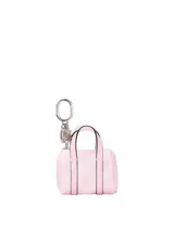 Llavero y colgante con forma de bolso en miniatura, color rosado, fabricado en piel sintética con textura granulada, asas superiores y herrajes metálicos plateados.
