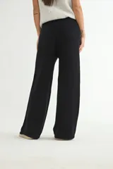 Pantalón tejido de corte recto y tiro alto, color beige, con cintura elástica ajustable mediante cordón y costura central vertical en cada pierna.