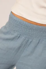 Pantalón celeste de corte palazzo, con cintura elastizada y tiro alto.