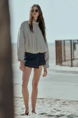 Chaqueta estilo bomber con estampado de cuadros vichy en blanco y negro, de cuello subido, manga larga y bolsillos delanteros de vivo. Cuenta con bajo abullonado y cierre frontal con cremallera oculta.