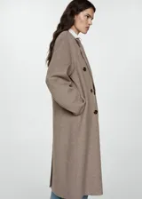 Abrigo largo de diseño oversize con tejido de lana, cuello con solapas de muesca y cierre frontal de doble botonadura. Presenta hombros caídos, manga larga y dos bolsillos laterales, con una abertura posterior en el bajo.