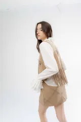 Pollera corta de simil gamuza color beige, con diseño de pespuntes decorativos en forma de rombos y cierre posterior.