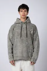 Buzo canguro oversize de algodón friza con efecto de teñido artesanal desgastado. Presenta capucha con cordones negros, bolsillo frontal tipo canguro y estampa pequeña de Popeye en el pecho.