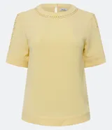 Blusa color amarillo pálido en crepé con cuello redondo, mangas cortas y detalles cutout en el cuello y en las mangas.