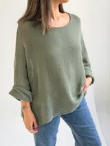 Sweater de punto calado en color verde seco, con escote redondo, mangas largas anchas y diseño holgado.