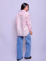 Camisa de manga larga a rayas verticales celestes y blancas, de corte suelto, confeccionada en algodón.