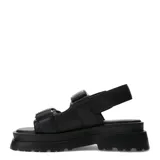 Sandalias negras estilo chunky de plataforma con suela dentada y dos tiras anchas con cierre de velcro, decoradas con tachas metálicas doradas.