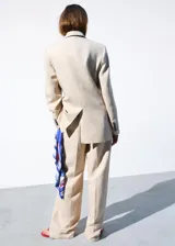 Pantalón de vestir de tiro medio, corte recto y largo, confeccionado en mezcla de lino y viscosa. Cuenta con trabillas en la cintura, dos bolsillos laterales y cierre frontal con gancho y cremallera.