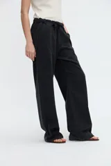 Jean estilo relaxed de color gris oscuro, con calce holgado, pierna amplia de caída fluida, cintura con cordón ajustable y bolsillos laterales.