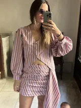 Camisa semi entallada de popelina 100% algodón, con estampado de cuadros tartán en tonos verde militar y azul oscuro. Presenta escote en V, cierre frontal con botones oscuros y mangas largas abullonadas con volumen.