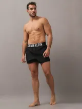 Pack de dos bóxer Calvin Klein de algodón elástico, uno negro y otro azul petróleo, con cinturilla elástica con logo de la marca.