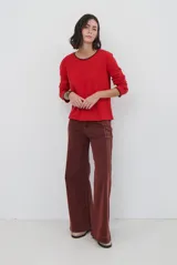 Remera de manga larga en color azul marino, confeccionada en tejido suave. Presenta un delicado detalle de bordado festoneado en color blanco tanto en el cuello redondo como en los puños, aportando un toque distintivo a esta prenda básica.