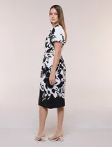 Vestido midi de calce fluido con escote redondo y mangas cortas abullonadas con terminación elástica. Presenta un fino cinturón a tono para ajustar la cintura y una falda evasé con estampa floral abstracta en blanco y negro.