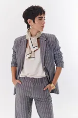 Blazer gris con rayas verticales blancas, confeccionado en lino y algodón.