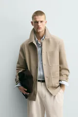 Sobrecamisa relaxed fit color beige confeccionada en tejido de algodón con estructura canvas, cuello solapa, manga larga con trabilla en los puños, bolsillos frontales de plastrón y cierre de botonadura.