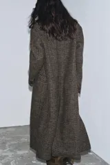 Abrigo largo de Zara Woman Collection, confeccionado en tejido con mezcla de lana. Presenta un diseño de cuadros, cuello con solapas de muesca, cierre frontal cruzado con botones y bolsillos delanteros. Incluye forro interior.