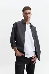 Camisa manga larga color verde oliva, corte slim fit, con cartera abotonada, dos bolsillos frontales con botón y confeccionada en 100% algodón.