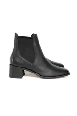 Botín tipo Chelsea confeccionado en cuero vacuno con textura floater. Presenta paneles laterales elásticos, punta ligeramente cuadrada y tacón de bloque.