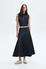 Pollera tobillera de denim de algodón rígido, color azul oscuro, con corte acampanado y cintura clásica con cierre oculto lateral.